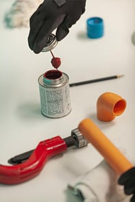 Aplicação de cimento solvente em tubo de CPVC