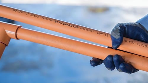 Person holding two pieces of BlazeMaster CPVC Pipe 