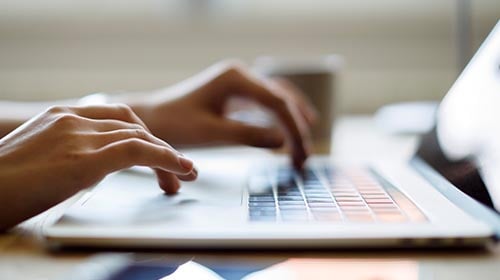 persons hands on a laptop keyboard
