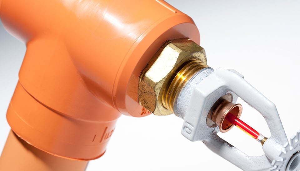 close up view of orange sprinkler and pipe